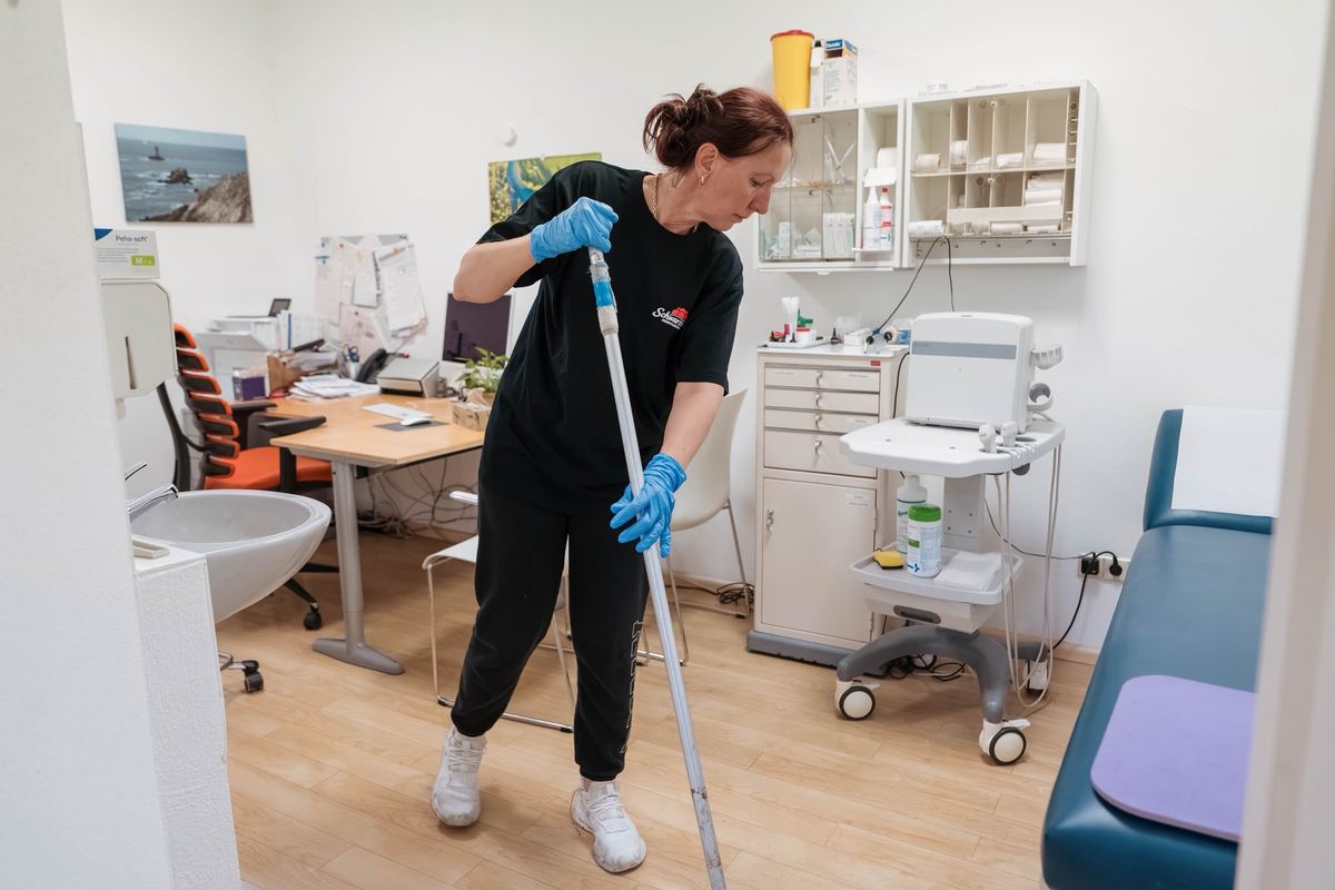 Mitarbeiterin von Schwarzwald Dienstleistungen reinigt den Boden in einem Behandlungszimmer